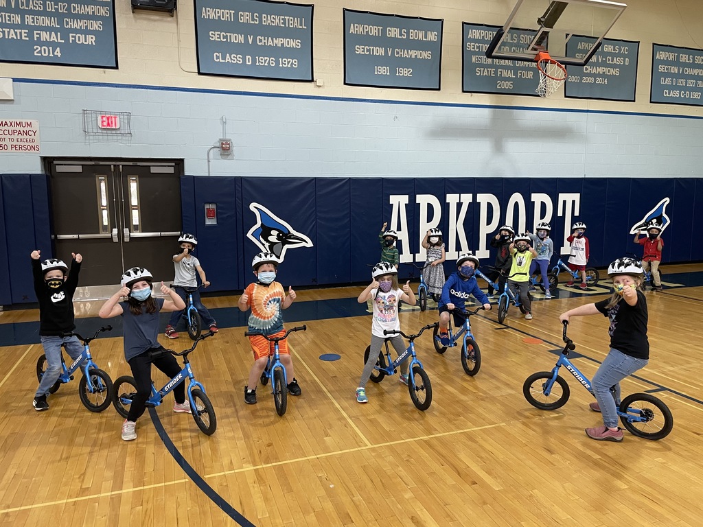Students sit on donated strider bikes