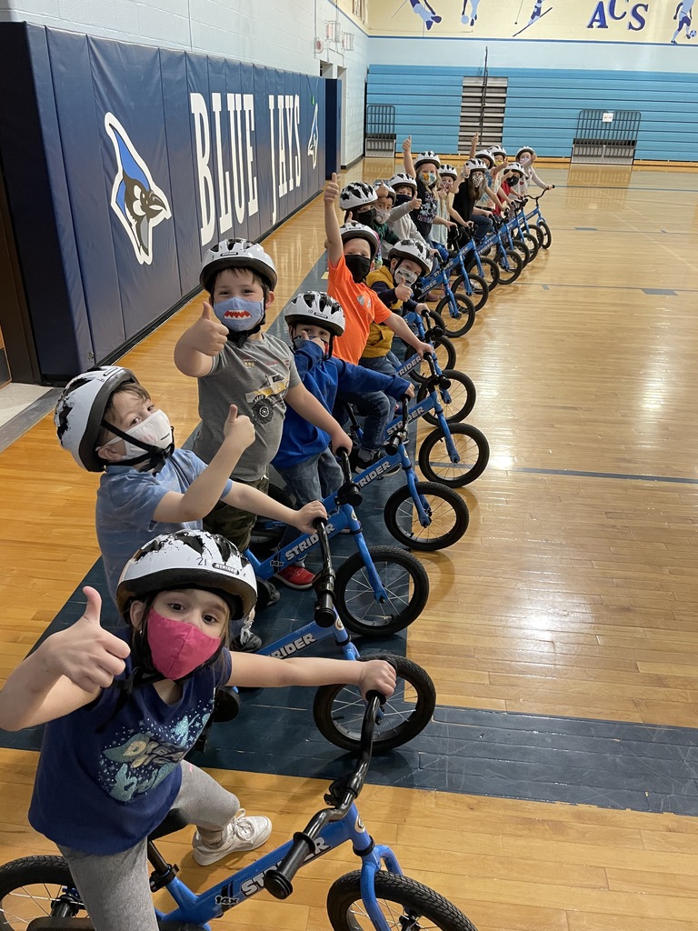 Students sit on donated strider bikes